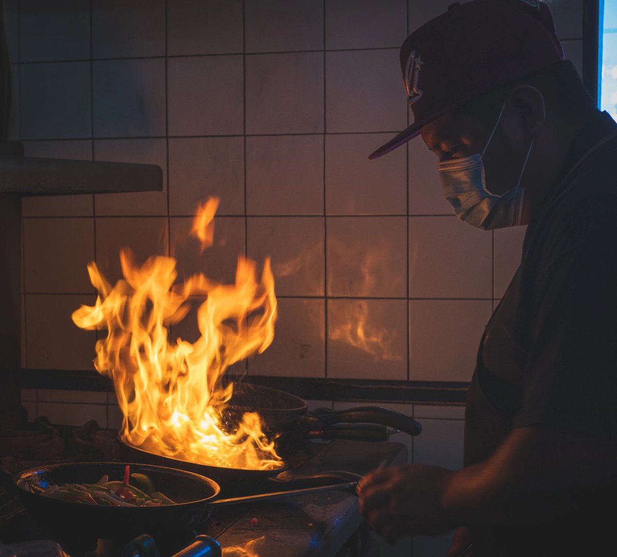 Flames leap from a pan on the iGuey kitchen line